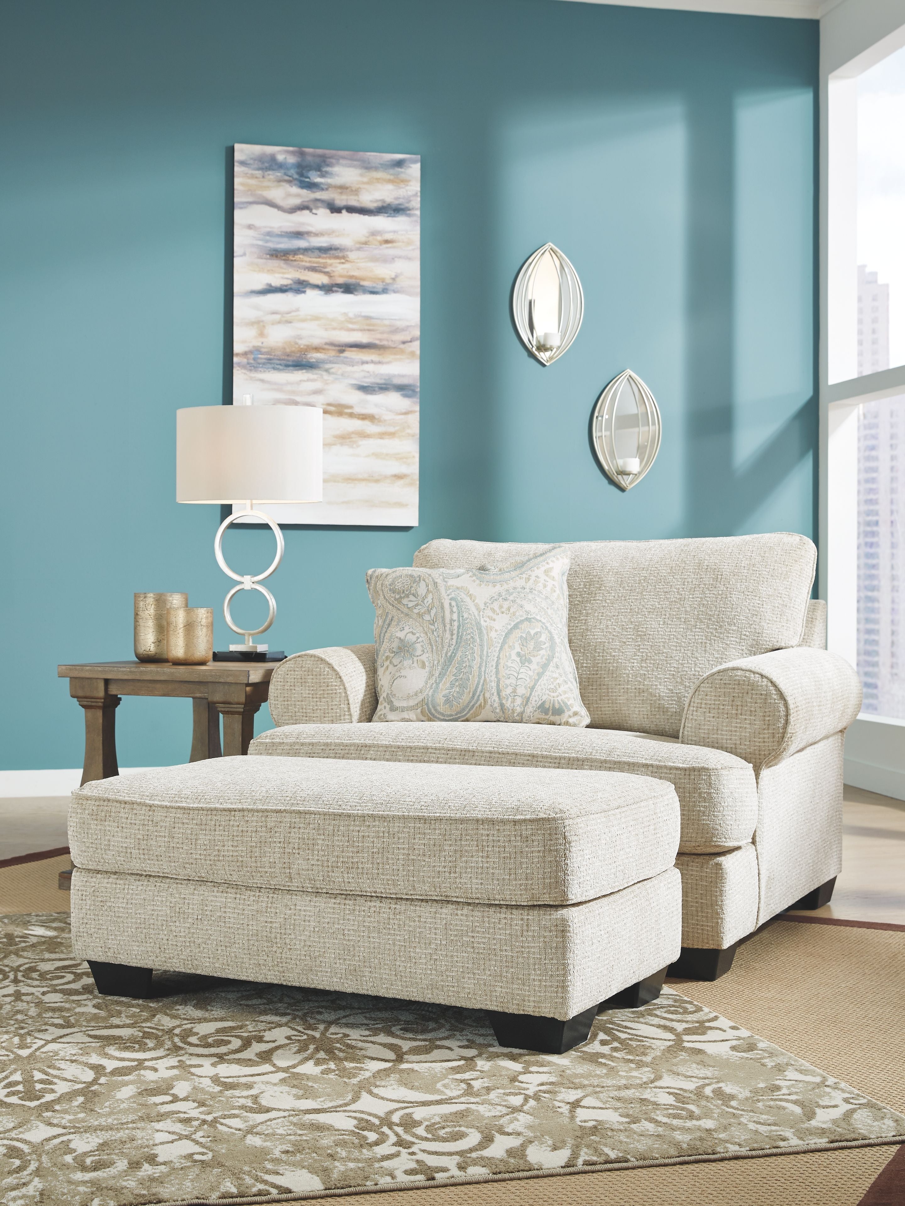 Upholstered loveseat with light beige fabric and two blue patterned pillows