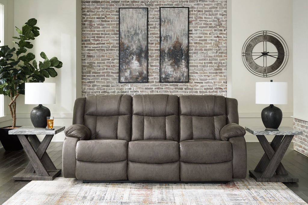 Dark gray reclining sofa with tufted back and three-cushion seat