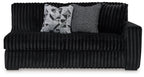 Dark velvet sofa with tufted front, rounded arms, and two throw cushions