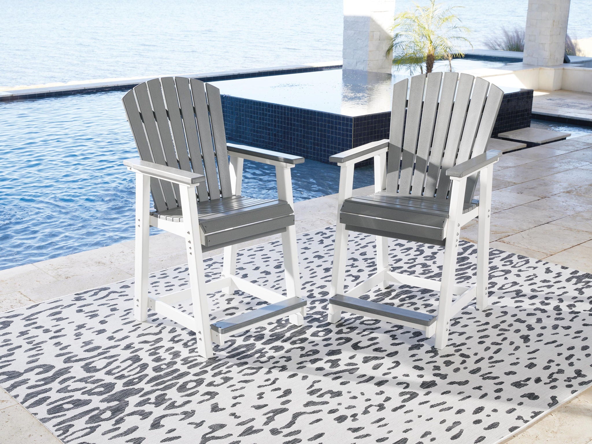Outdoor set of 2 gray slat-back barstools with armrests and gray seats on white frames