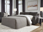 Sofa sleeper with bed extended, gray upholstery and dark throw pillows.