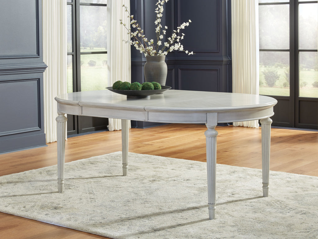 Antique white oval extension dining table with straight skirt and turned legs