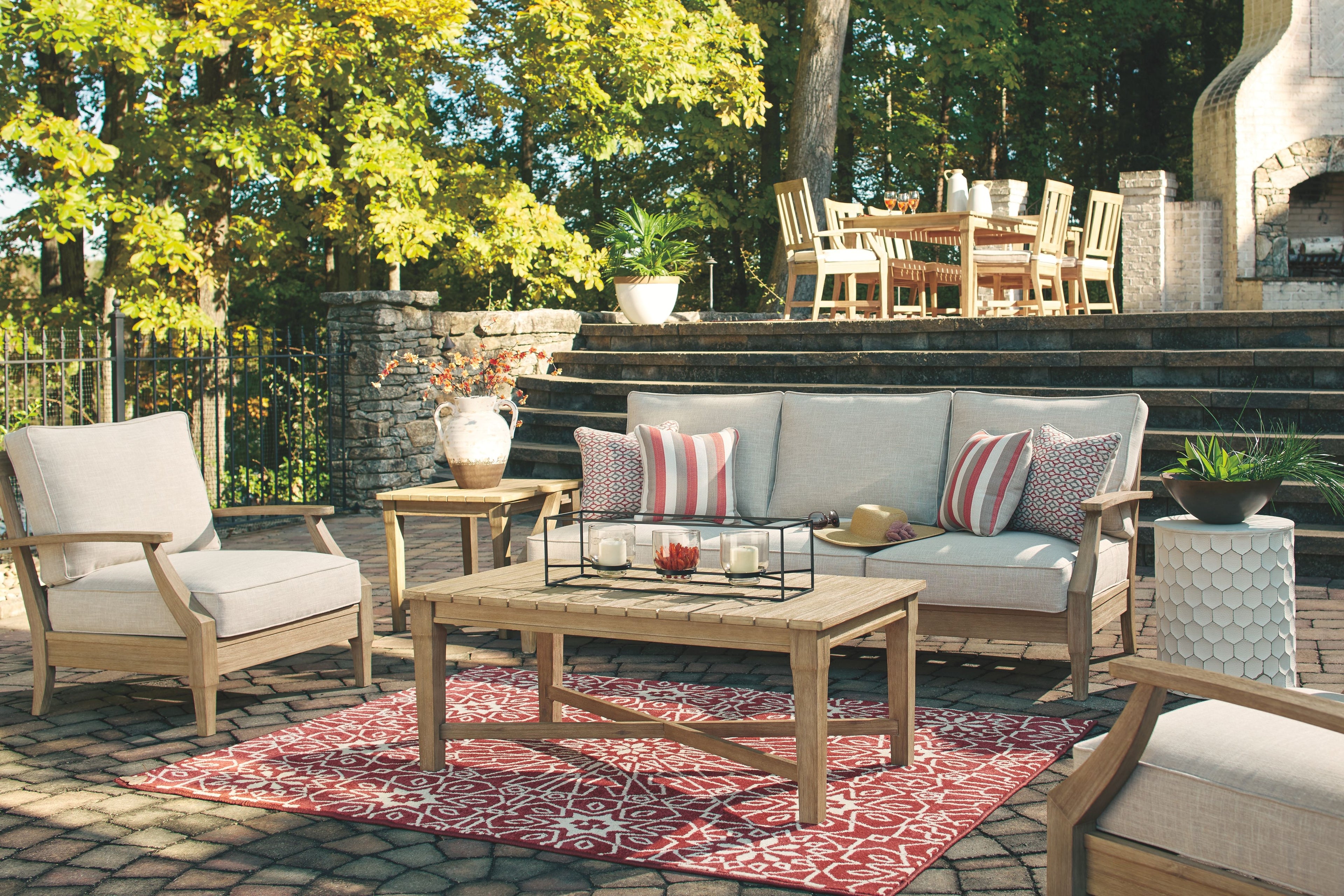 Beige sofa with stacked armrests and four cushions with red-and-white stripes
