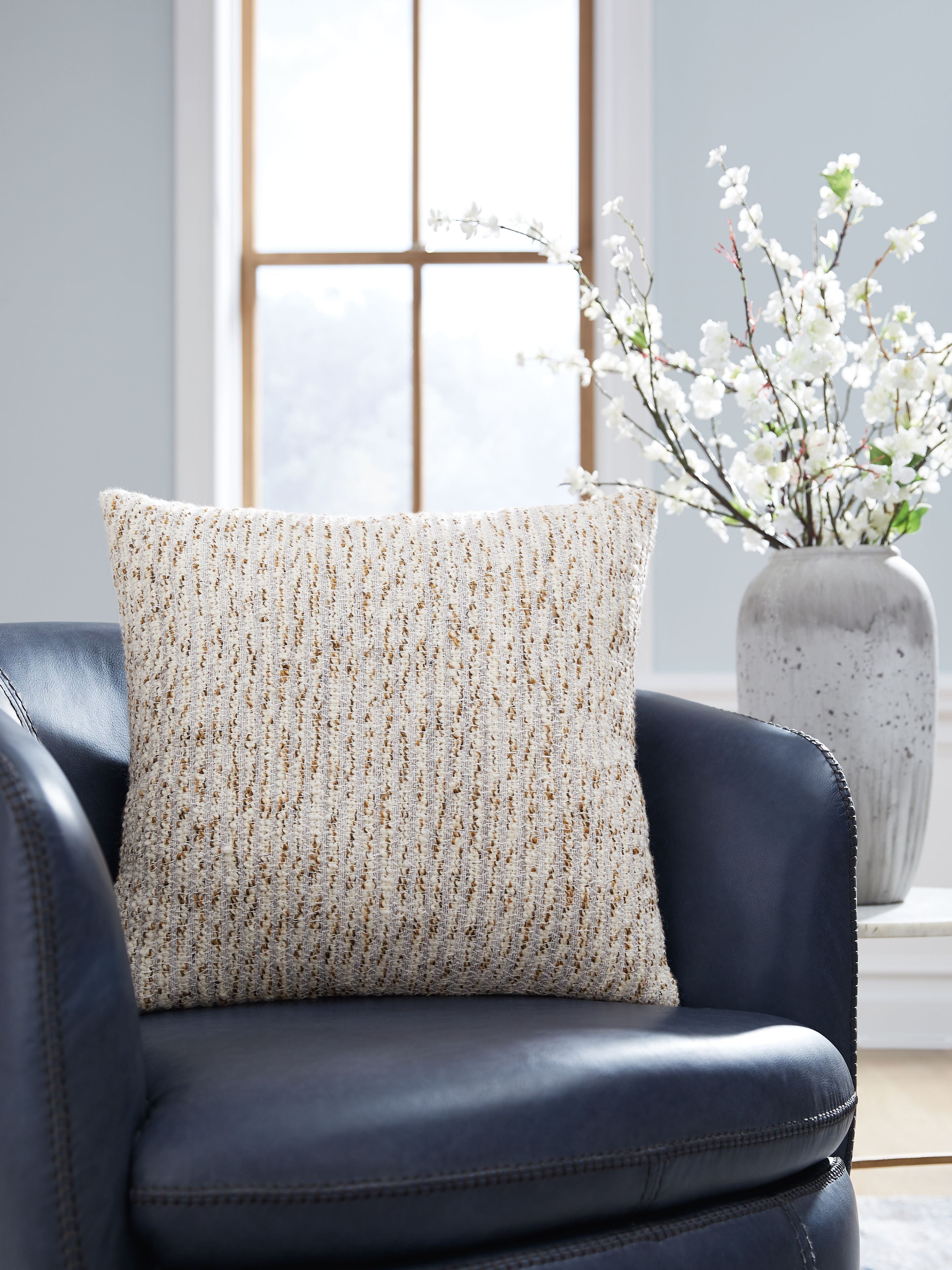 Abler beige textured pillow on armchair, woven front with solid reverse