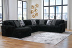 Black corduroy sectional sofa with chaise corner and patterned throw pillows