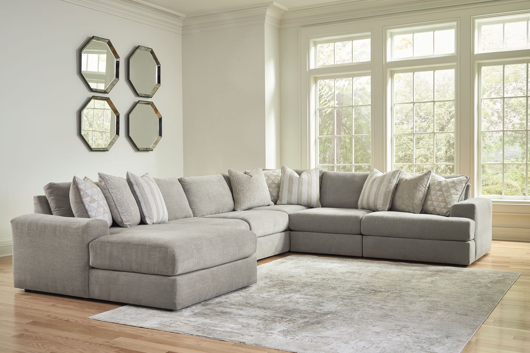 Gray sectional sofa with chaise and multiple accent pillows on a rug