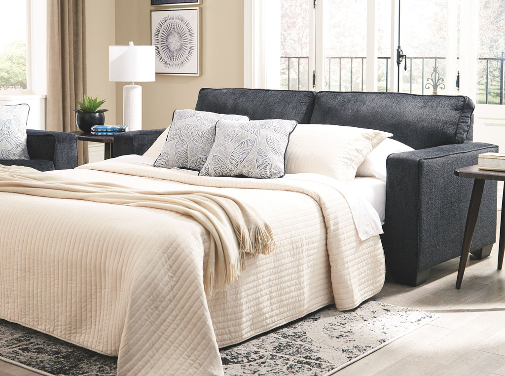 Slate sleeper sofa with extended mattress and white quilted bedding and pillows