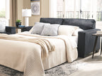 Slate sleeper sofa with extended mattress and white quilted bedding and pillows