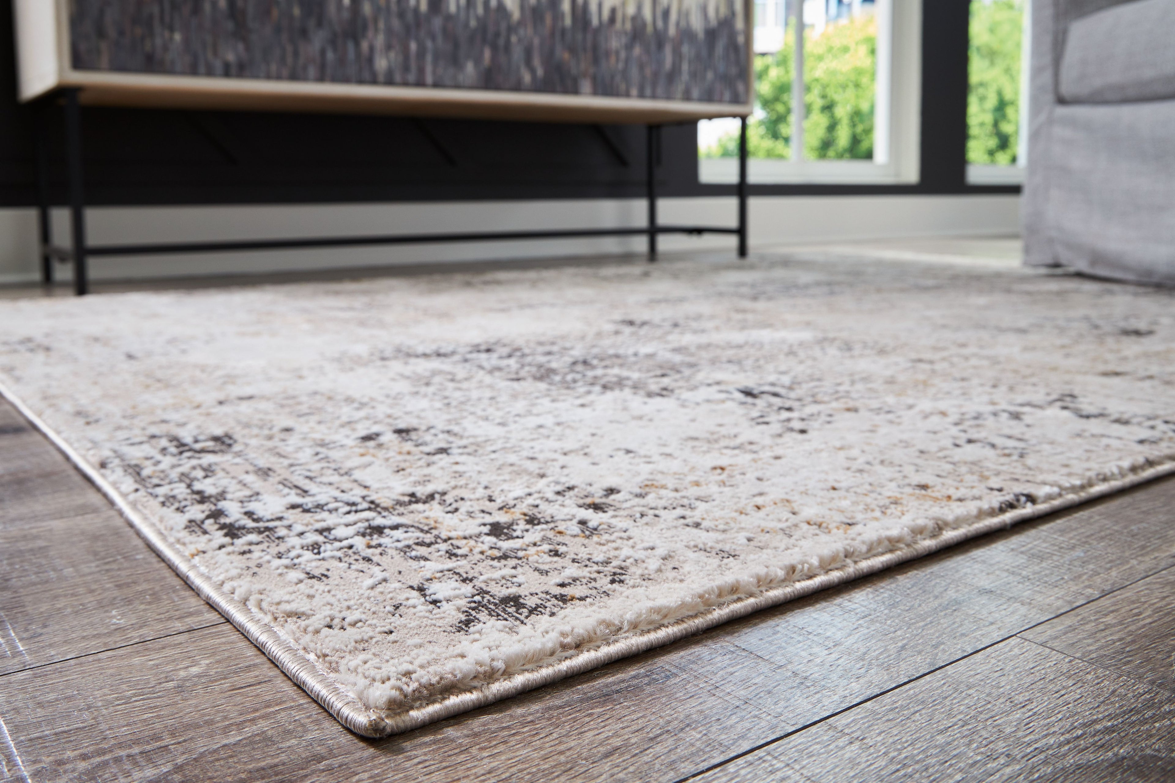 Dark gray distressed area rug with abstract pattern and bound edges