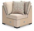 Beige corner chaise sectional with two front pillows and small blue fabric tabs