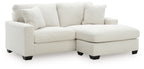 White upholstered sofa with chaise extension, square arms, and back pillows