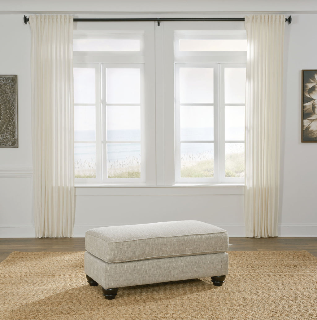 Light gray upholstered ottoman with square seat and exposed legs