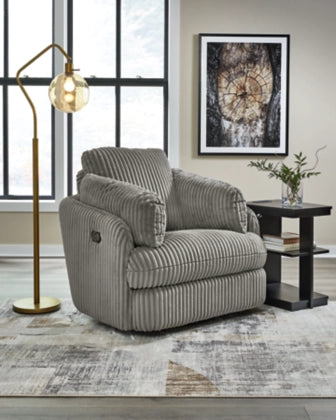 Gray ribbed swivel glider recliner with padded headrest and side arm pocket.