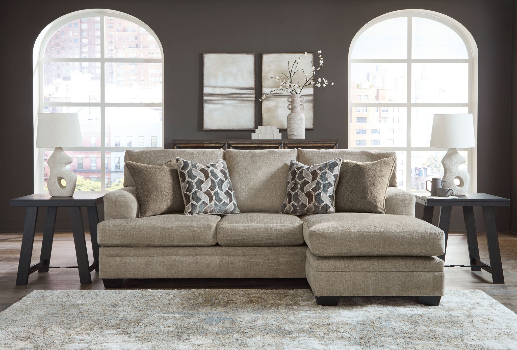 Sectional sofa with chaise in light brown fabric, five pillows with geometric print