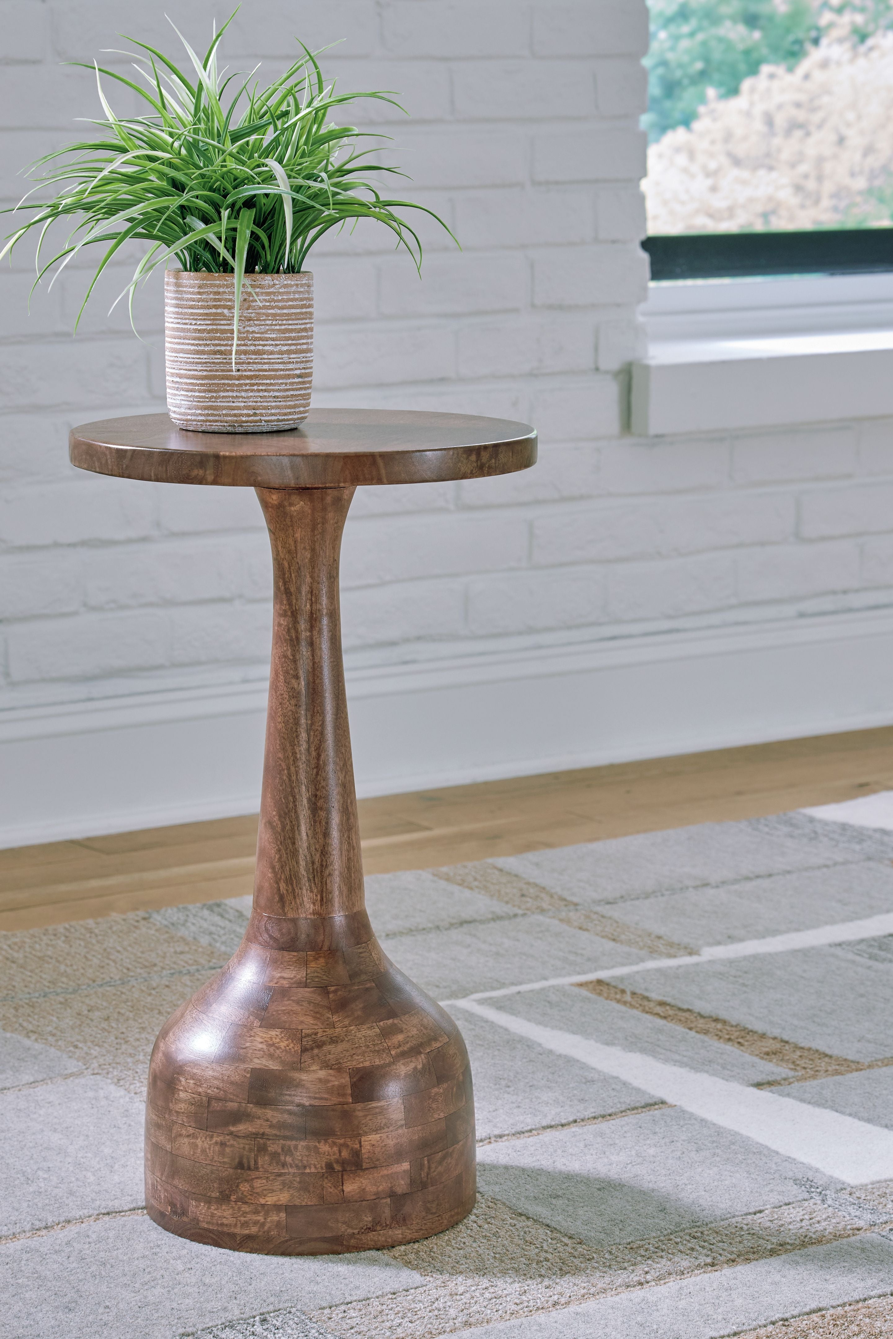 Medium brown accent table with round top and turned pedestal base, inlaid wood texture