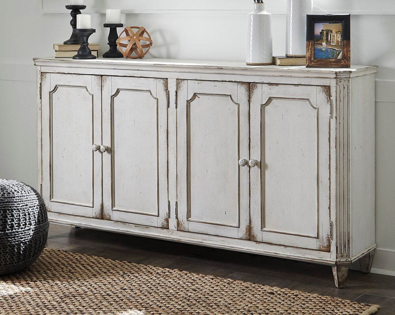 Antique white accent cabinet with four paneled doors and distressed finish