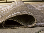 Rolled edge of brown rug with cream geometric stripes and frayed fringe