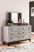 Gray dresser with mirror, multiple drawers with black bar pulls, farmhouse-style legs