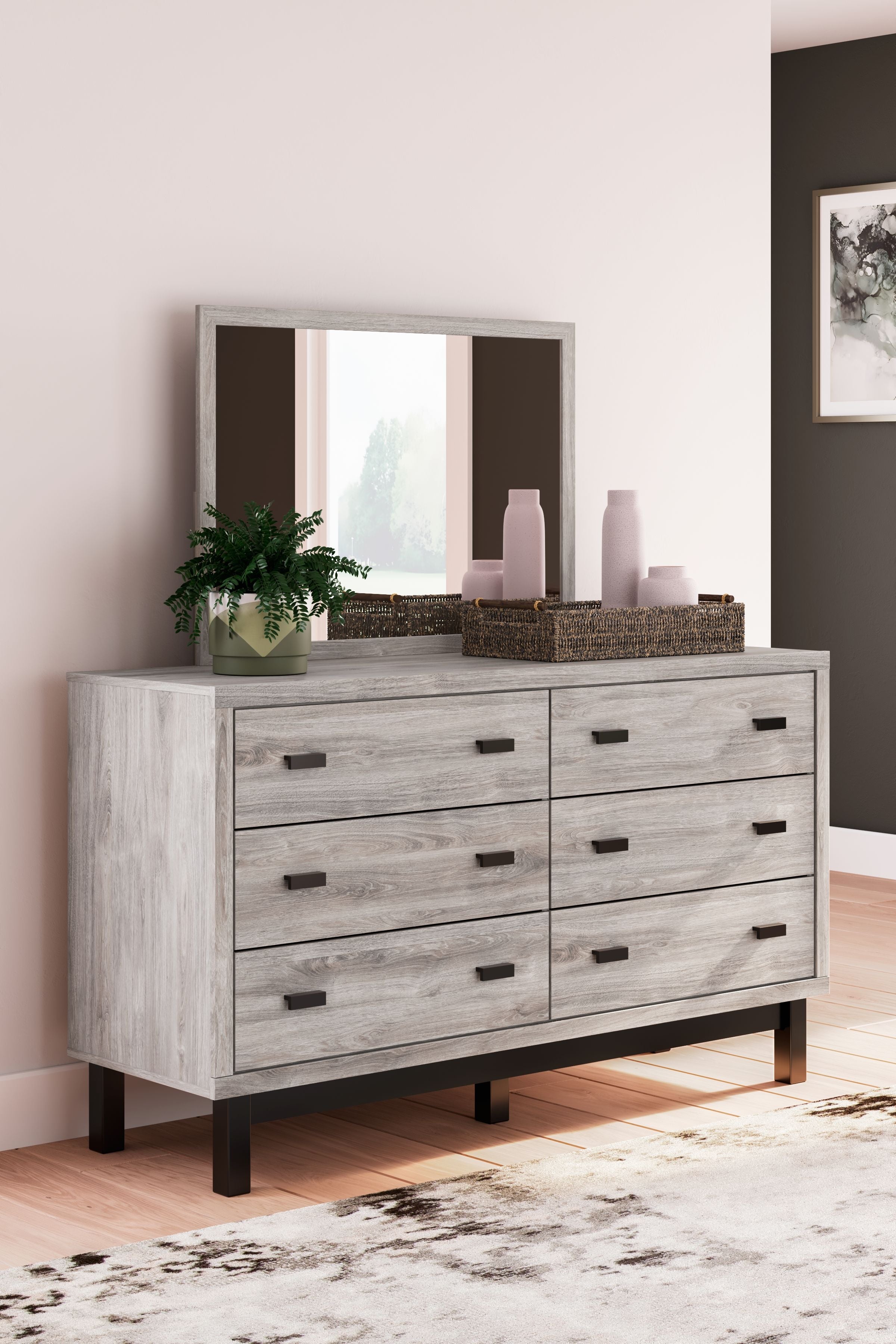 Gray dresser with mirror, multiple drawers with black bar pulls, farmhouse-style legs