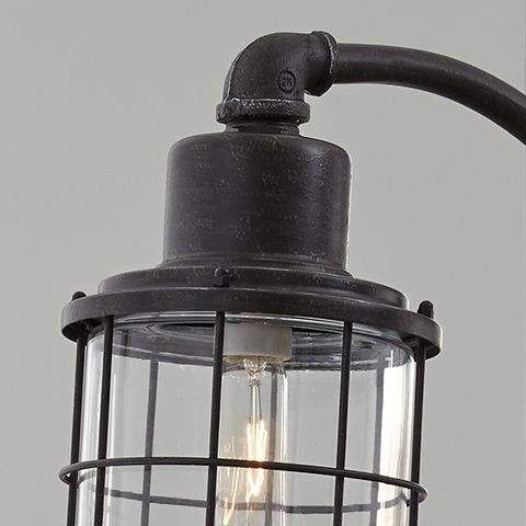 Antique black metal lamp head with glass globe cage and exposed filament bulb