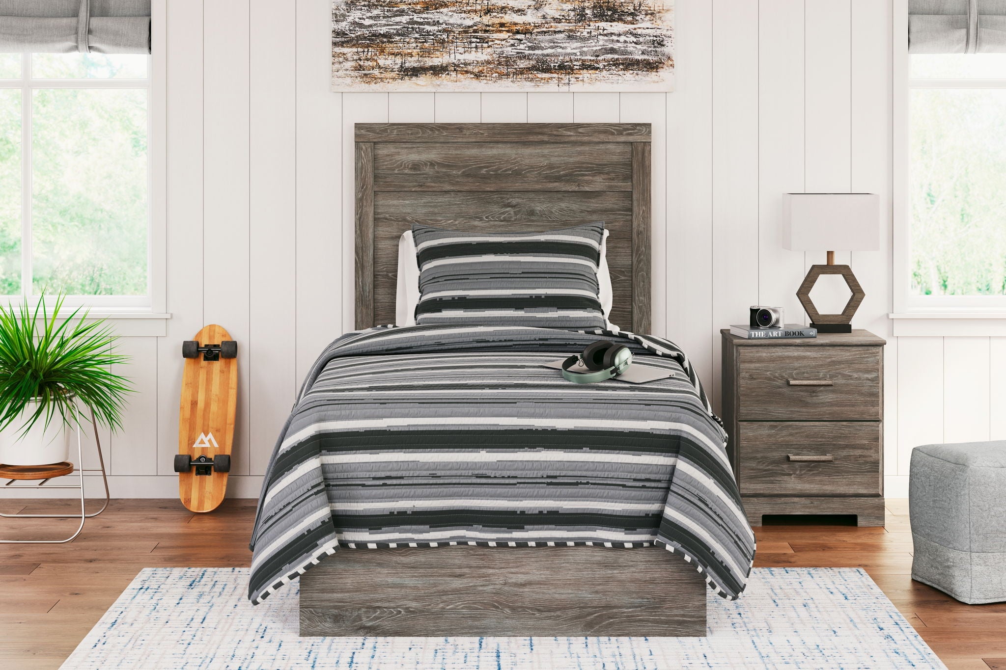 Dark gray wood-look panel bed with striped bedding and layered blankets