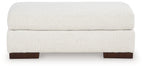 Cream upholstered ottoman with rounded top and dark wooden feet, low profile