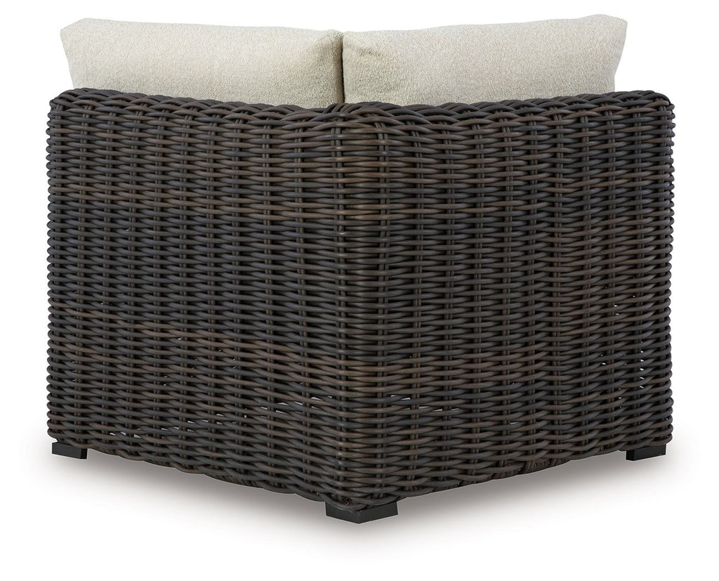 Corner sofa chair with beige back cushions on dark brown wicker