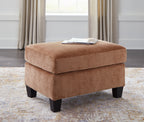 Upholstered clay ottoman with cushioned top and dark legs for seating or footrest