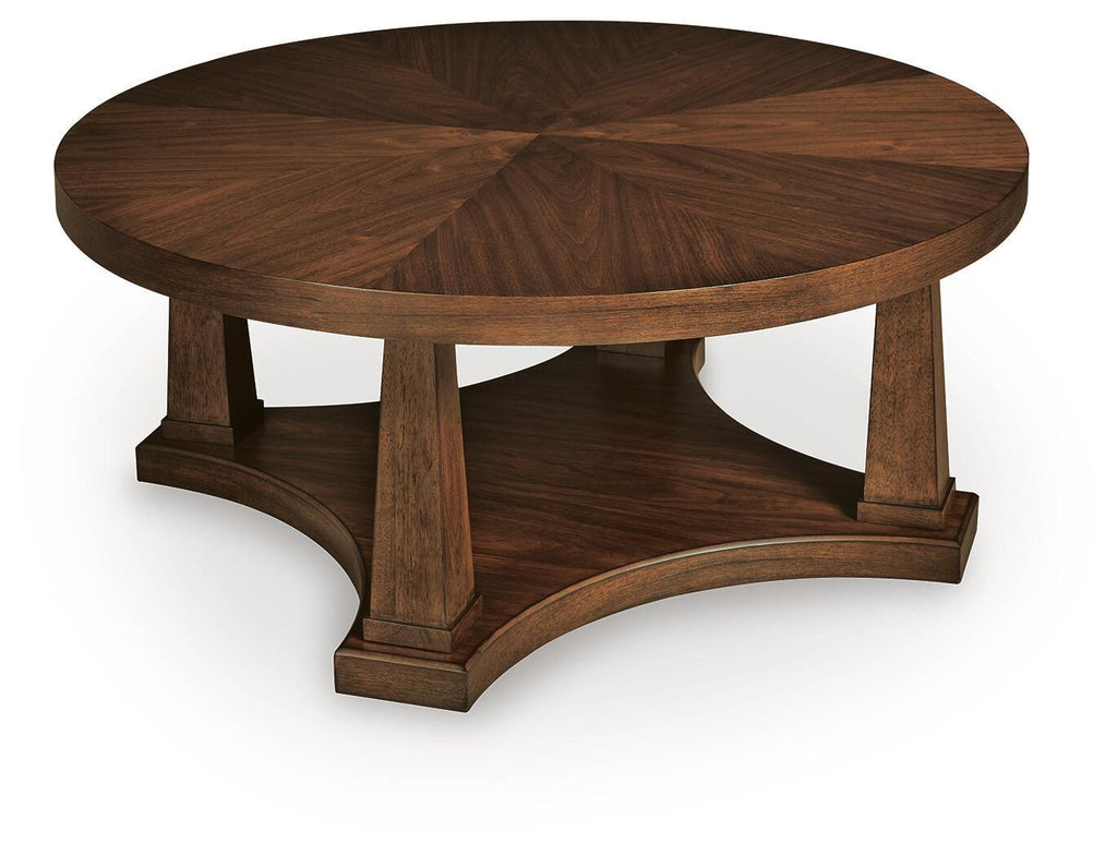 Round wooden coffee table with light brown top and pedestal base, angled view
