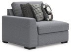 Gray corner chair with side profile, black legs, and zigzag and geometric throw pillows