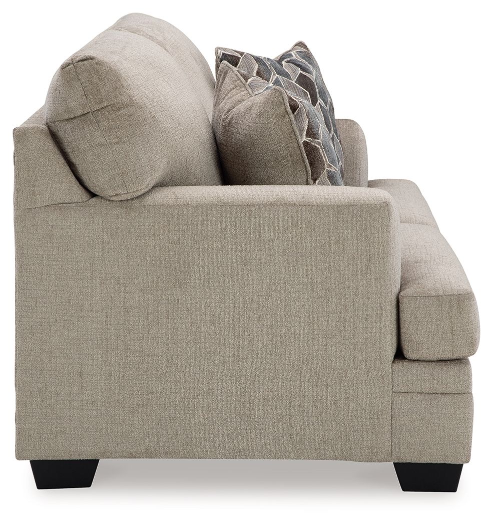 Light beige fabric loveseat with arm detail and two geometric patterned pillows