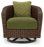 Brown woven swivel lounge chair with green seat cushion and patterned green back pillow