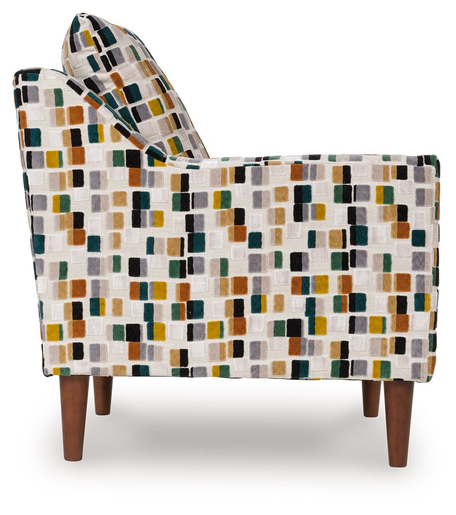 Multicolor patterned accent chair with square fabric, side view, padded arms, dark wood legs.
