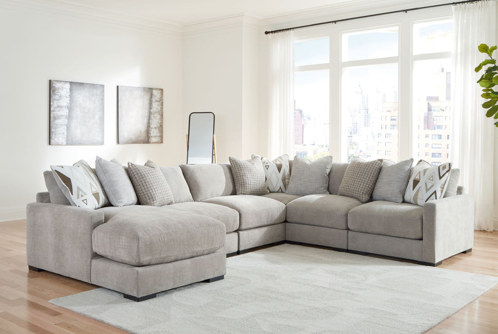 Light gray sectional sofa with chaise and patterned throw pillows in an L-shaped layout