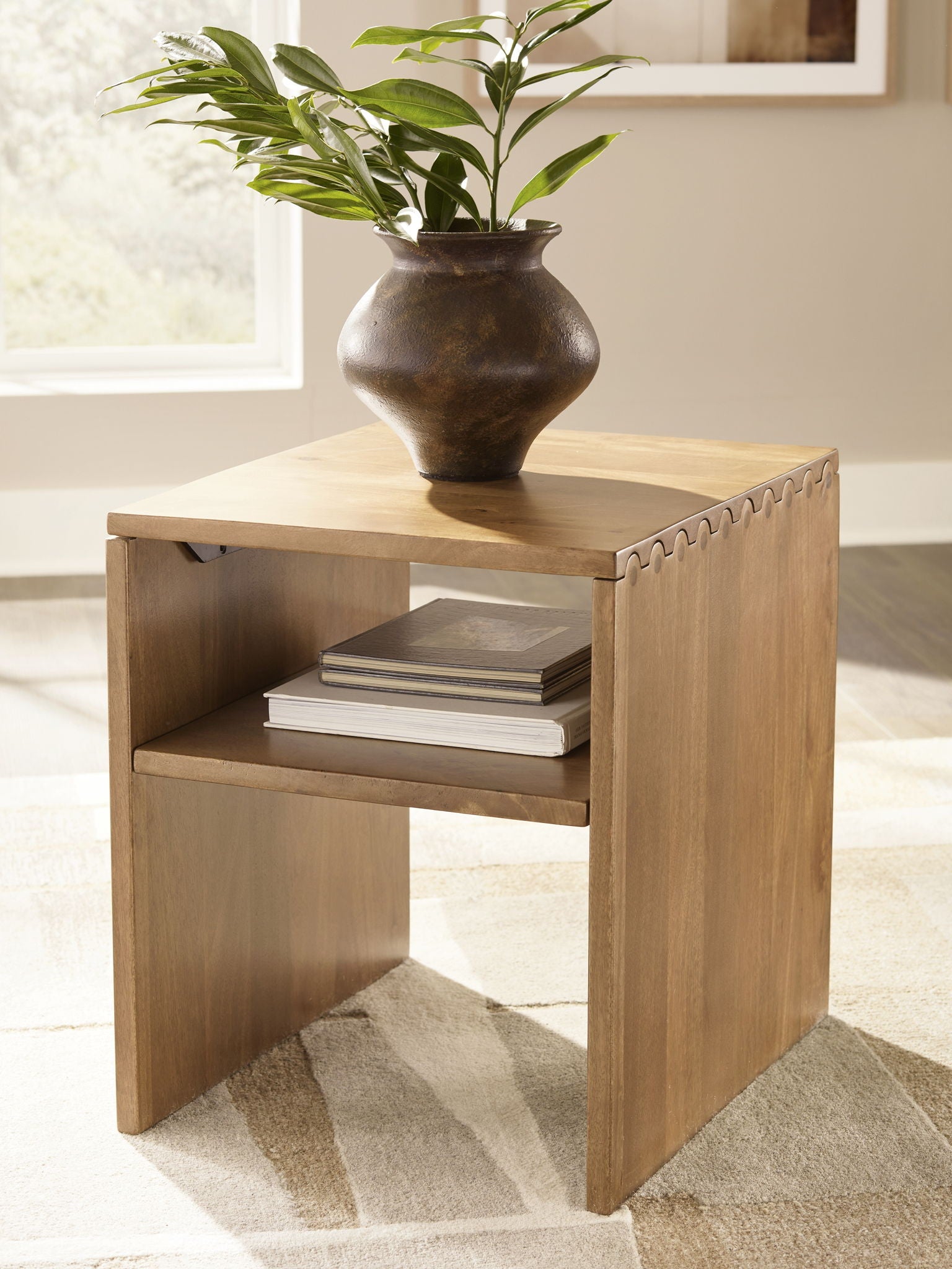 Light brown rectangular table with open shelf, styled with vase and stacked books