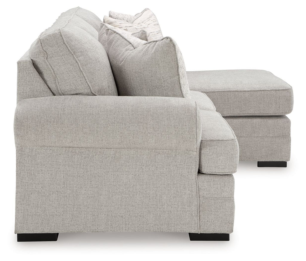 Gray upholstered armchair with rolled arms and decorative throw pillows