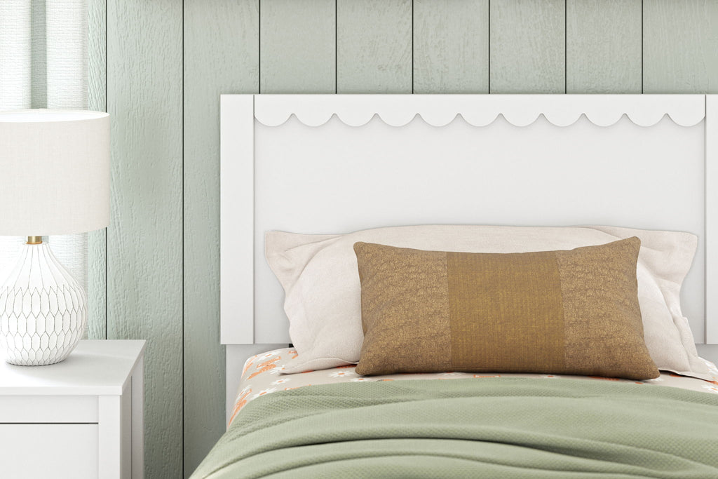 White panel headboard with scalloped top, styled behind pillows and bed linens