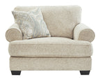 Sandstone chair and a half with rolled arms, light textured upholstery and patterned accent pillow