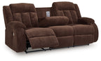 Chocolate brown reclining power sofa with padded arms and tufted back cushions