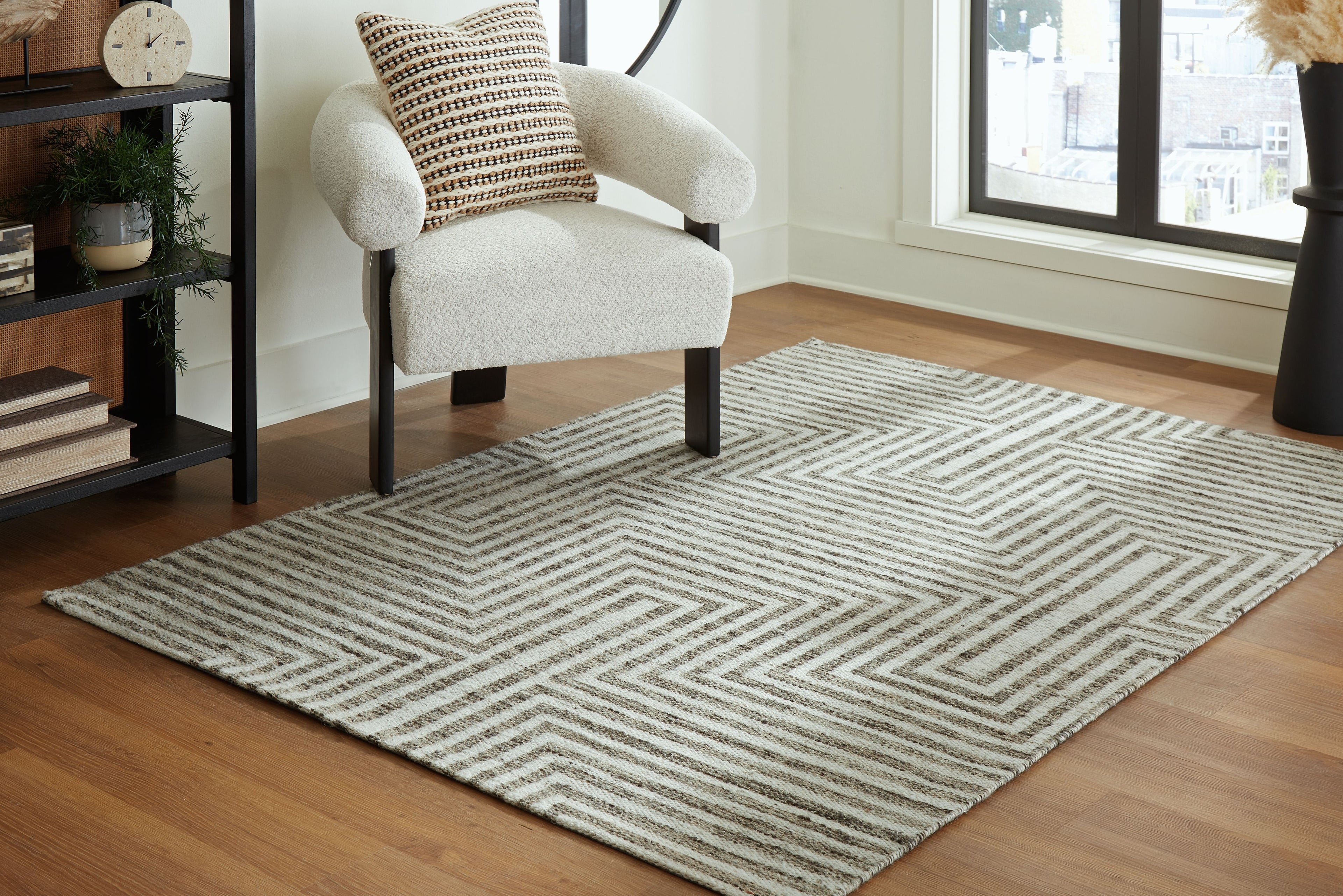 Gray chevron-pattern area rug with corner angled view on floor