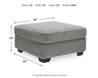 Gray upholstered accent ottoman with padded top and short block feet