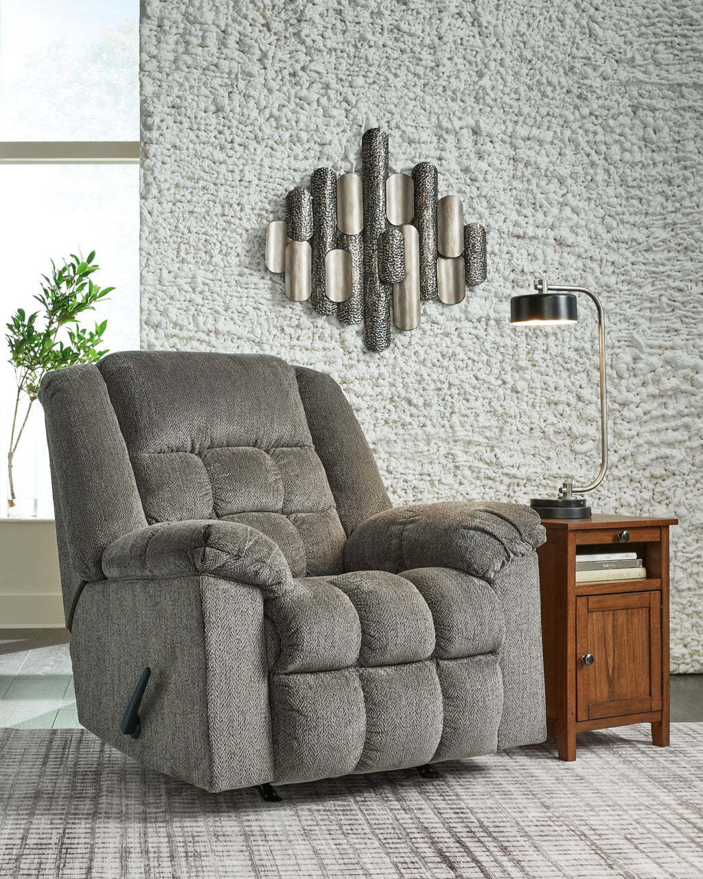 Gray rocker recliner chair with tufted back and cushioned seat, slightly reclined