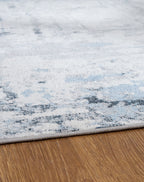 Light blue washable rug with faded abstract bands and mottled low-pile texture