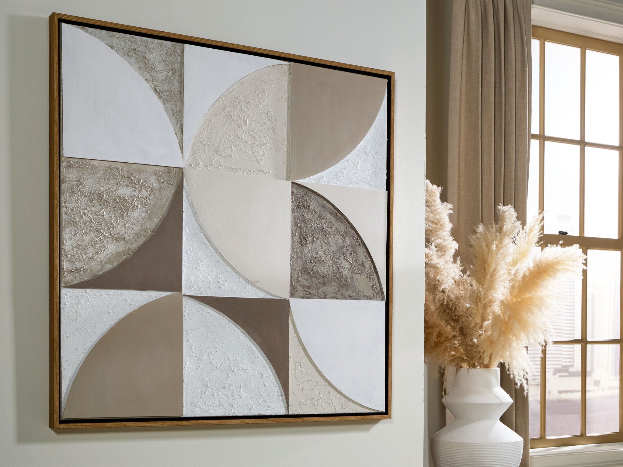 Framed wall art featuring geometric circle pattern in taupe, tan, and white