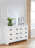 White dresser with attached mirror and six drawers with bronze cup handles
