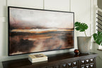 Abstract wall art print in brown, black, and orange hues hanging on wall, black frame