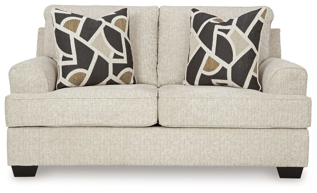 Light beige loveseat front view with two geometric black-and-beige throw pillows and dark feet