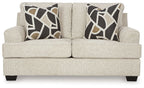 Light beige loveseat front view with two geometric black-and-beige throw pillows and dark feet