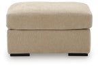 Beige fabric ottoman with cushioned top and black block legs, front view
