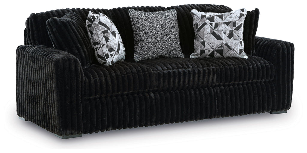 Black corduroy sofa with two patterned throw pillows and a textured center back cushion.